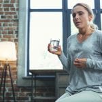 woman drinking water and sweating