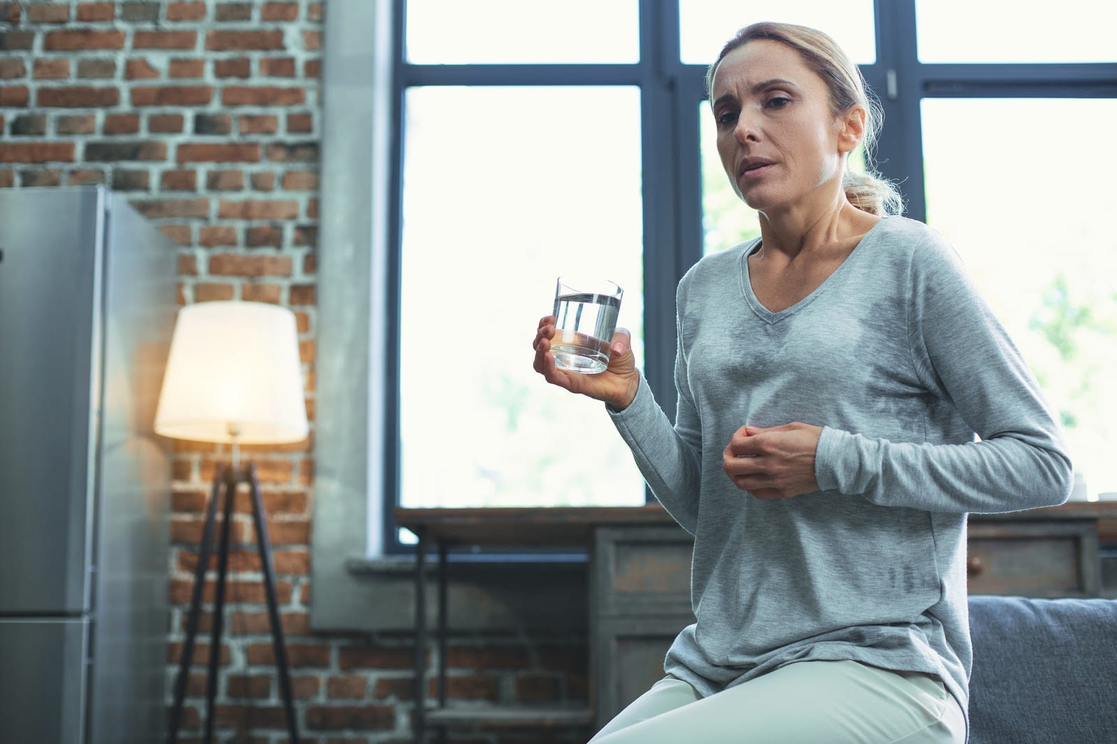 woman drinking water and sweating