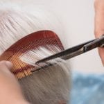 Hair stylist cutting senior woman's gray hair ** Note: Shallow depth of field