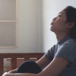 depression asian woman is sad and stress in bedroom, close up at face