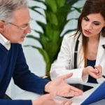 Doctor talking to his patient and showing documents. Focus on the doctor