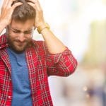 Young handsome man over isolated background suffering from headache desperate and stressed because pain and migraine. Hands on head.