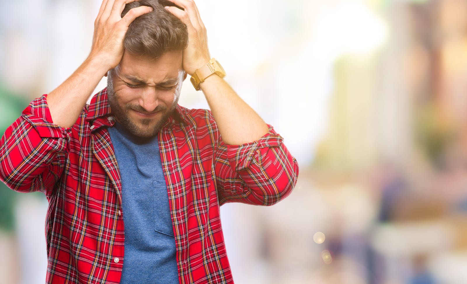 Young handsome man over isolated background suffering from headache desperate and stressed because pain and migraine. Hands on head.