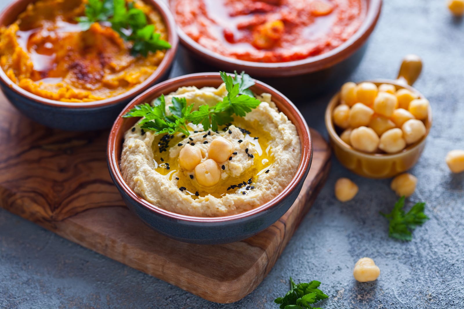 pumpkin hummus red pepper hummus and lentils hummus on wooden table