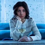 Woman drinking wine on a couch