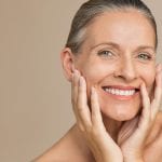 A woman smiles and feels fresh following proper skincare treatments.