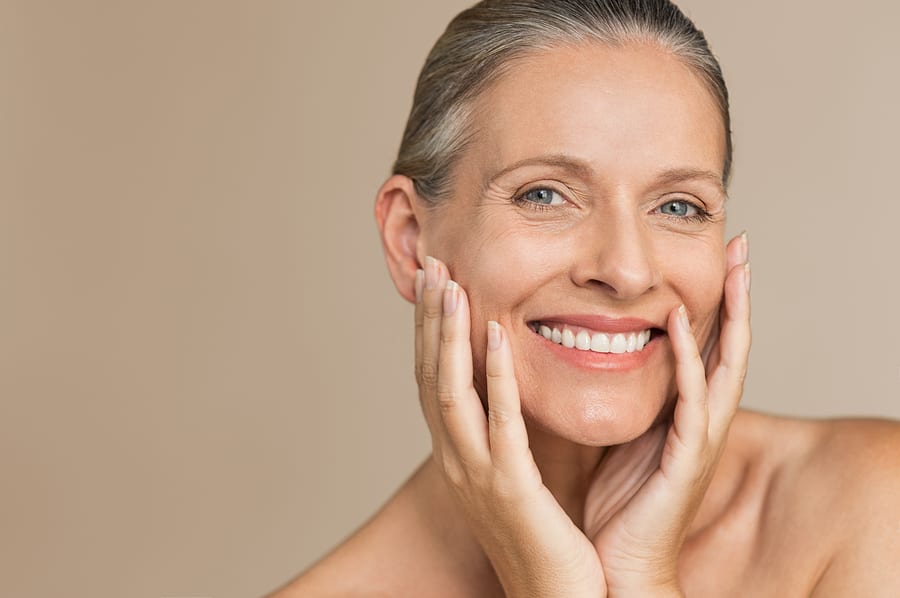 A woman smiles and feels fresh following proper skincare treatments.