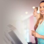 woman working out on a treadmill smiling at the camera