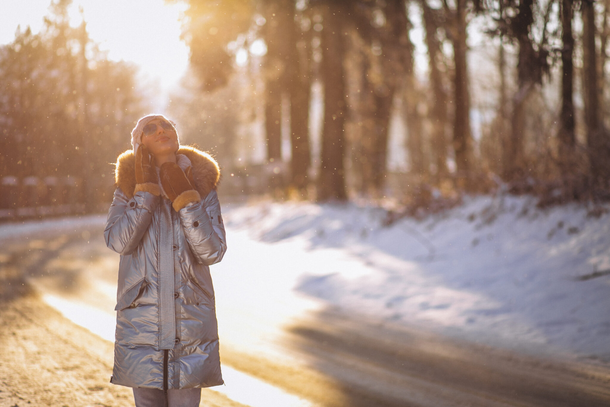 A woman taking a winter walk in the park, getting exercise and soaking up sunlight to help boost her energy during the colder months.